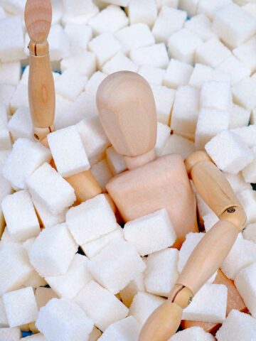 fake-body-covered-by-mounds-of-cane-sugar-cubes-suggesting-sugarholic