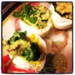 a plate odeviled eggs made with guacamole cut in halves on a plate