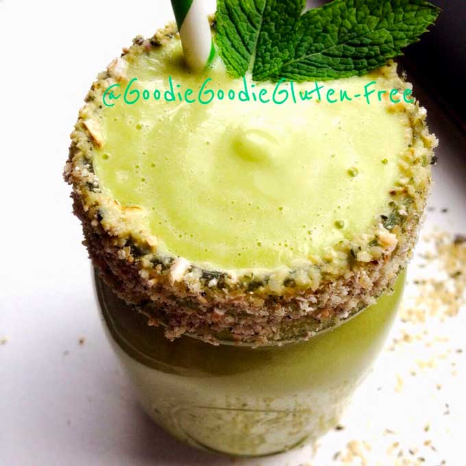 a lime green colored mint smoothie in a mason jar with a hemp seed crusted rim and mint leaves
