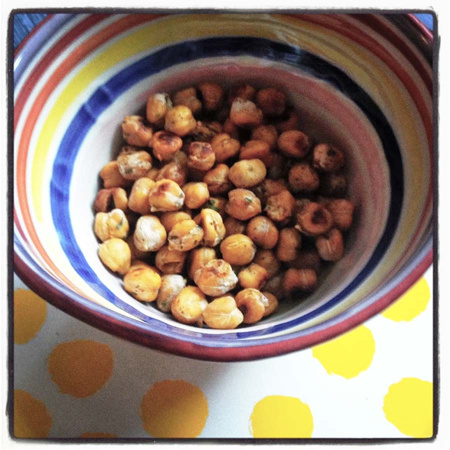 a handful of spicy crunchy chickpeas baked to perfection in a striped bowl